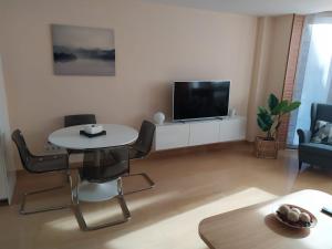 a living room with a tv and a table and chairs at Inmueble en Navas de Tolosa in Jaén