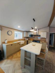 a kitchen with a table and a clock on the wall at Waters Edge Lodge with Hot Tub in York