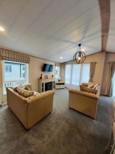 a large living room with two couches and a tv at Waters Edge Lodge with Hot Tub in York