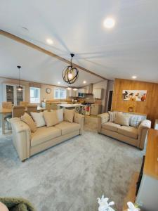 a living room with two couches and a kitchen at Waters Edge Lodge with Hot Tub in York