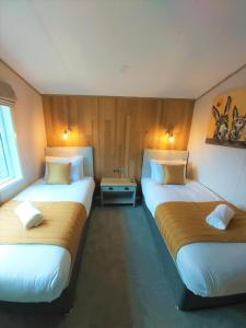 two beds in a hotel room with two at Waters Edge Lodge with Hot Tub in York +6 photos