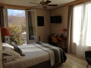 a bedroom with a bed and a window and a desk at Hôtel L'Iroko The Originals City in Aix-les-Bains