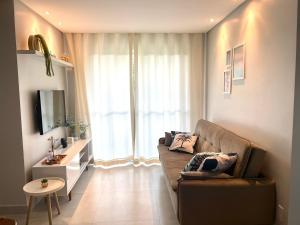 伊列乌斯Apê Ilha Graciosa, Praia dos Milionários Ilhéus-Ba的带沙发和大窗户的客厅