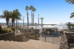 a view of a beach with palm trees and umbrellas at Bungalow Flamingo in Playa Blanca