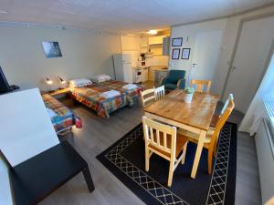 a living room with a table and a bedroom at Hotel Aakenus Economy Apartments Peura in Rovaniemi