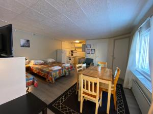 a room with a table and a bed and a bedroom at Hotel Aakenus Economy Apartments Peura in Rovaniemi