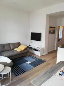 uma sala de estar com um sofá e uma televisão de ecrã plano em Turmstrasse19 em Wismar