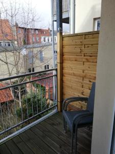 uma varanda com uma cadeira e uma cerca em Turmstrasse19 em Wismar