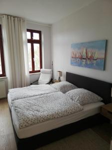 a bedroom with a bed and a painting of sailboats at Turmstrasse19 in Wismar