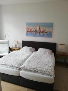 a bedroom with a bed with a painting of sailboats at Turmstrasse19 in Wismar