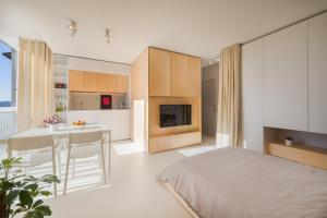 ein Schlafzimmer mit einem Bett und eine Küche mit einem Tisch in der Unterkunft Elegant Studio Apartment with Panoramic View in Nova Gorica