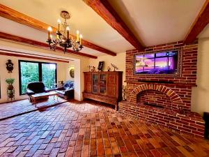 a living room with a brick fireplace and a tv at Cracow. Villa Cherubin Garden in Krakow