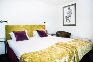 um quarto com uma cama grande e um cobertor dourado em HOF HOTEL em Kaunas