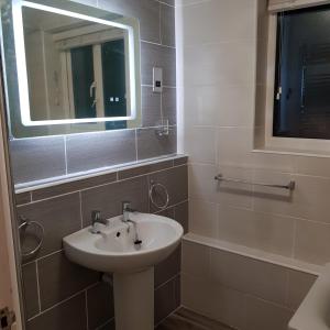 a bathroom with a sink and a mirror at Darcey's Apartment in Bowness-on-Windermere