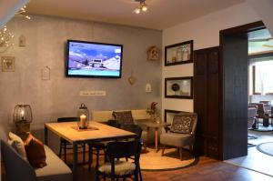 a living room with a tv on the wall at Dahoam by Sarina - Rooms & Suites in Zell am See