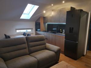 ein Wohnzimmer mit einem Sofa und einem Kühlschrank in der Unterkunft Nibela Apartments in Zagreb