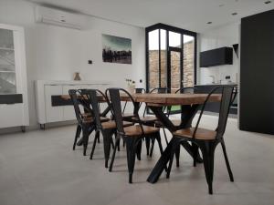 a dining room with a wooden table and chairs at Las Pasaeras in Montehermoso