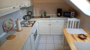 una pequeña cocina con armarios blancos y una encimera en Ferienwohnung direkt am See en Bad Saarow