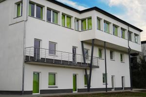 um edifício branco com janelas verdes e uma varanda em bp24 Hotel Eschweiler em Eschweiler