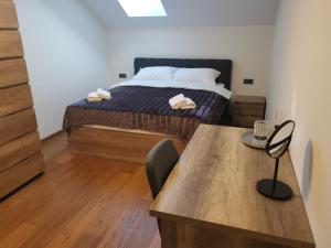 ein Schlafzimmer mit einem Bett und einem Holztisch in der Unterkunft Nibela Apartments in Zagreb