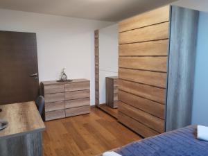 Schlafzimmer mit einem Bett und einer hölzernen Schiebetür in der Unterkunft Nibela Apartments in Zagreb