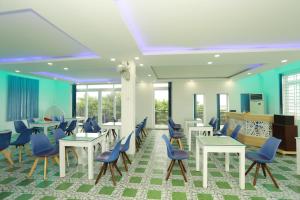 - une salle d'attente avec des tables et des chaises bleues dans l'établissement Lys Hotel, à Buôn Ma Thuột