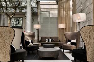 a lobby with couches and chairs and a table at H15 Boutique Hotel, Warsaw, a Member of Design Hotels in Warsaw