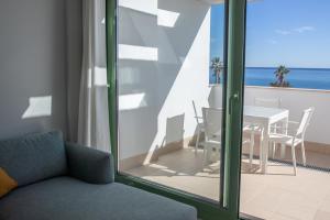 a living room with a table and chairs and a view of the ocean at Precioso apartamento frente a la playa con piscina in Mojácar