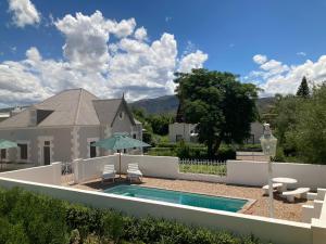 un patio trasero con piscina y una casa en 3 Queen Street en Calitzdorp