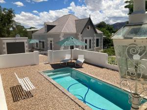 a house with a swimming pool in front of a house at 3 Queen Street in Calitzdorp