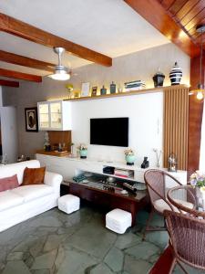a living room with a white couch and a tv at Apartamento Temporada Salvador in Salvador