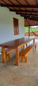 a large wooden bench sitting in front of a building at Chácara Sossego in Capitólio