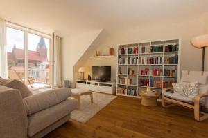 a living room with a couch and a book shelf at Residenz Darssblick in Barth