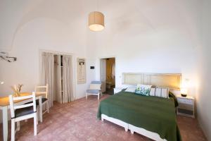 a bedroom with a bed and a table and a desk at Il Mulino di Scauri in Pantelleria