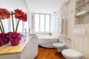 een badkamer met een toilet, een wastafel en een bad bij TOLENTINI Canal View & Terrace in Venetië