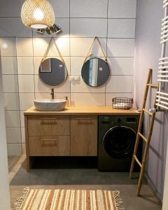 ein Bad mit einem Waschbecken und 2 Spiegeln in der Unterkunft Apartament Zoja in Elblag