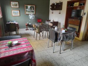 sala de estar con mesas, sillas y TV en MAMAKU HUASI en Cafayate