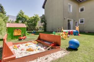 a sandbox with toys in a yard next to a house at Willa Linc Łeba in Łeba