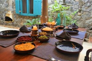 Stone Cottage في كاندي: طاولة مع العديد من الأطباق عليها