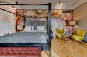 a bedroom with a large bed and yellow chairs at Grand Poet Hotel and SPA by Semarah in Rīga