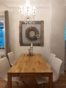 a dining room table with white chairs and a chandelier at Apartmenthaus Franzis in Bad Gastein