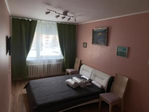 a bedroom with a bed with two chairs and a window at Mõisavahe 30 two big beds 1 single bed in Tartu