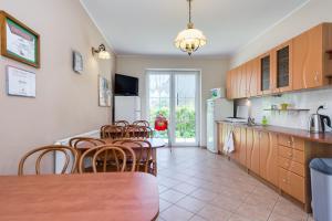 a kitchen with a table and chairs in a room at Willa Linc Łeba in Łeba