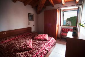 a bedroom with a red bed and a window at Hotel Aurora in Spiazzi Di Caprino