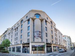 un gran edificio blanco en la esquina de una calle en Hotel Nice Riviera, en Niza