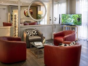ニースにあるホテル ニース リビエラの赤い椅子とテレビ付きの待合室