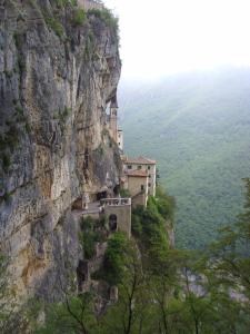 a building on the side of a cliff at Hotel Aurora in Spiazzi Di Caprino