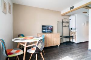 a room with a table and chairs and a tv at Stay in Cervinia Deluxe Apartment in Breuil-Cervinia