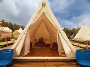 Cibitung 2的住宿－Ciawitali Glamping，前面设有两把蓝色椅子的大帐篷