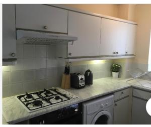 a kitchen with a stove and a counter top at Arma Short Stays 46 Bicester - Sleeps 3 - Free Parking & Garden in Bicester
